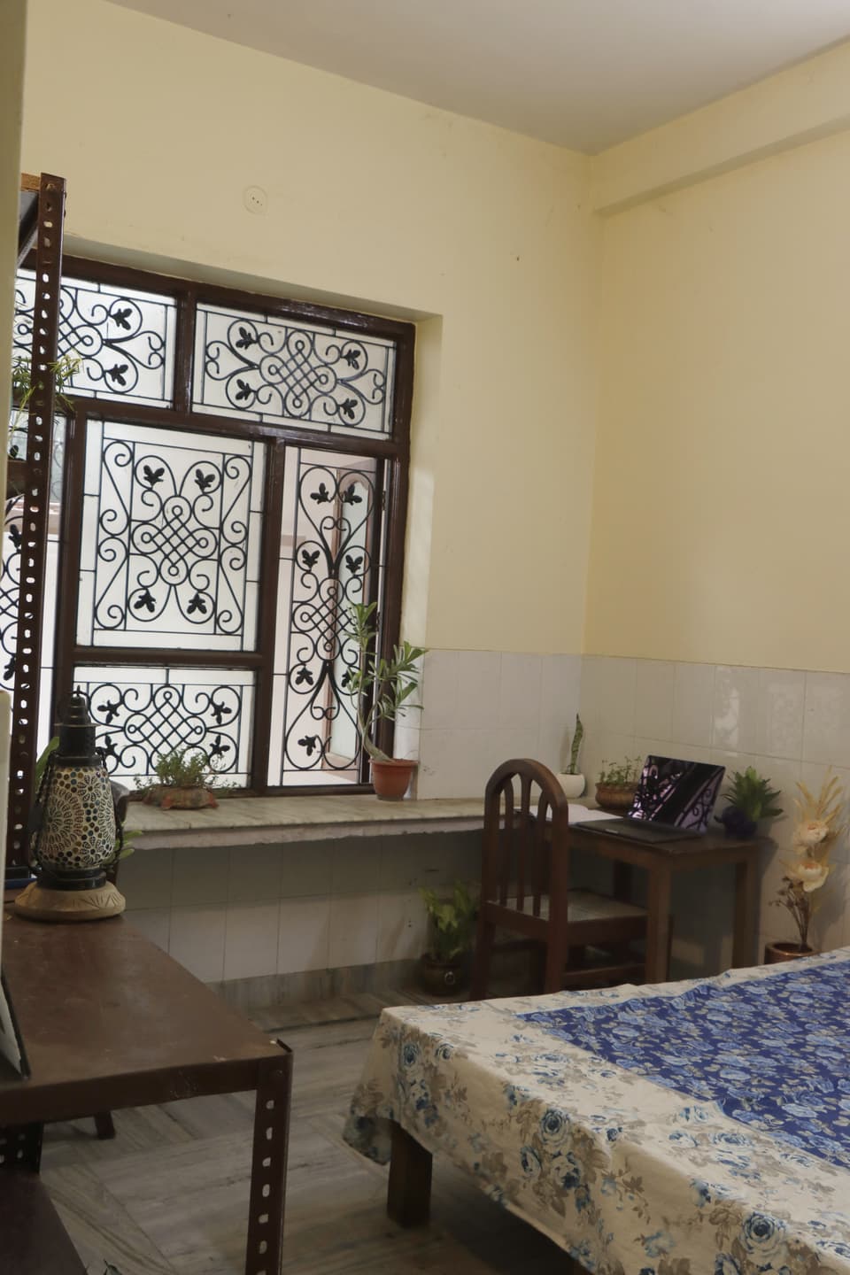 Bed, study table, and large window inside the room.