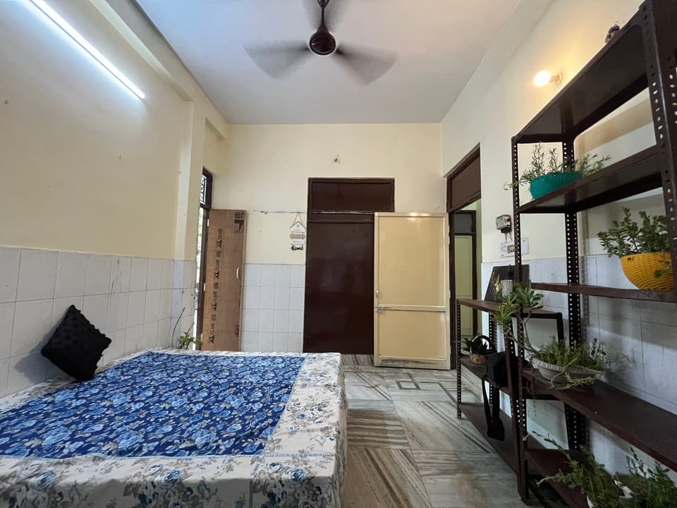 Bed, storage cupboard, and open shelving inside the room.