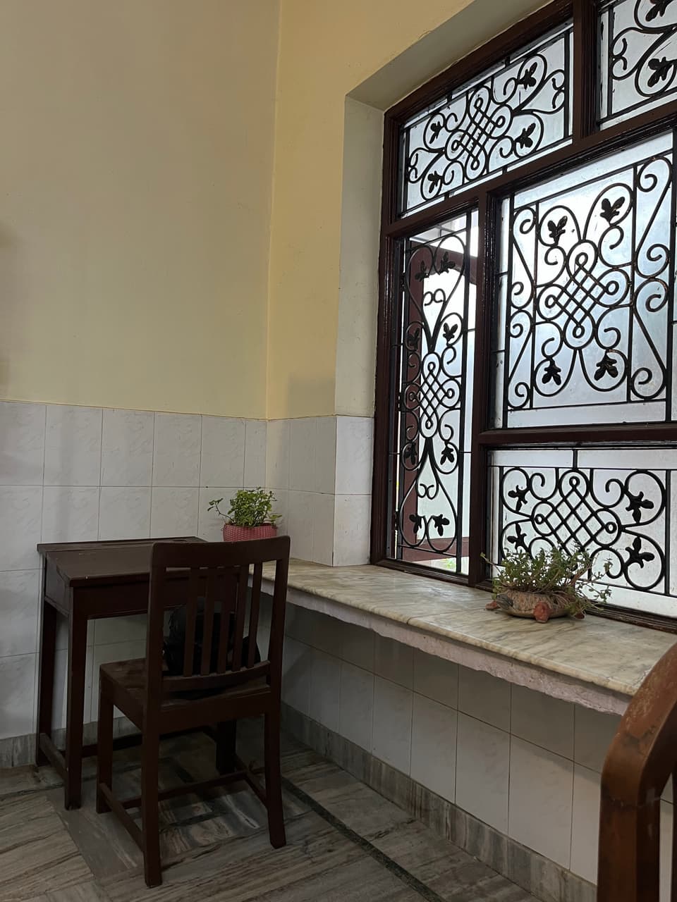 Study table beside the large grilled window.