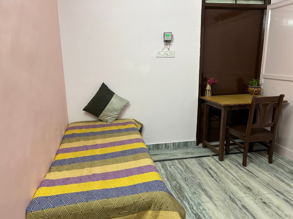 Compact single-room layout with study desk and clean walls.