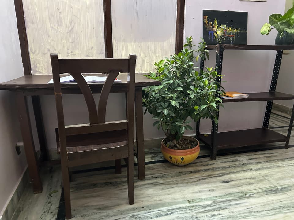 Alternative angle of the compact solo room with desk and shelving.