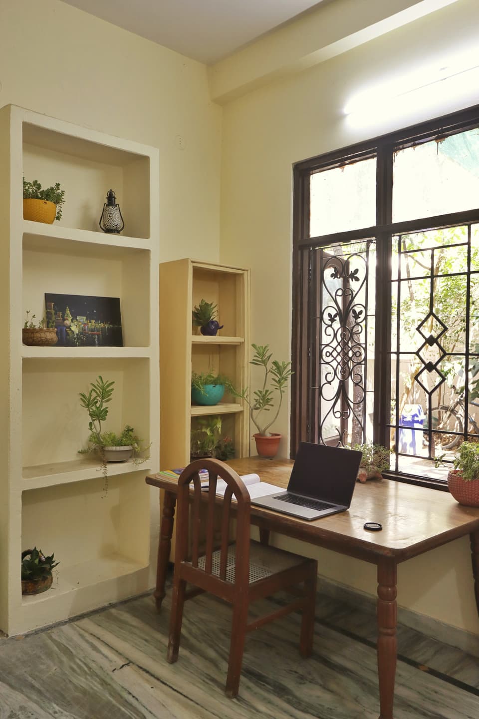Study desk and built-in shelves beside the courtyard-side window.