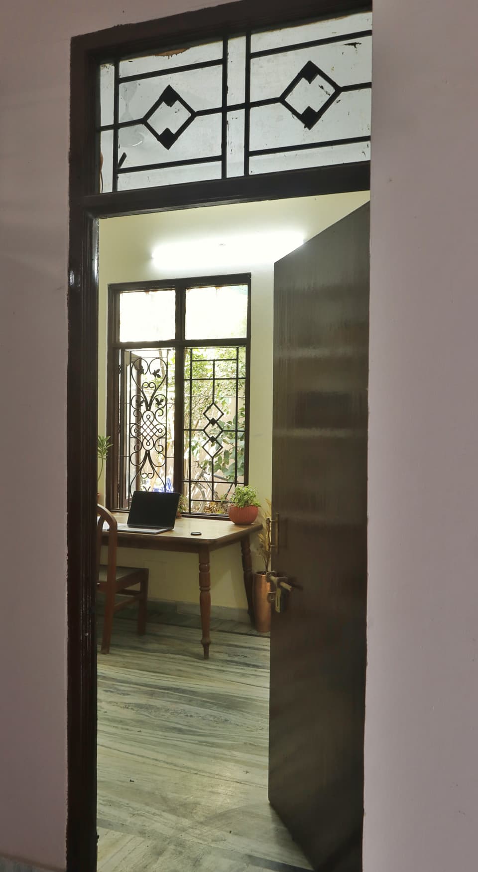 Study desk and window seen through the room doorway.