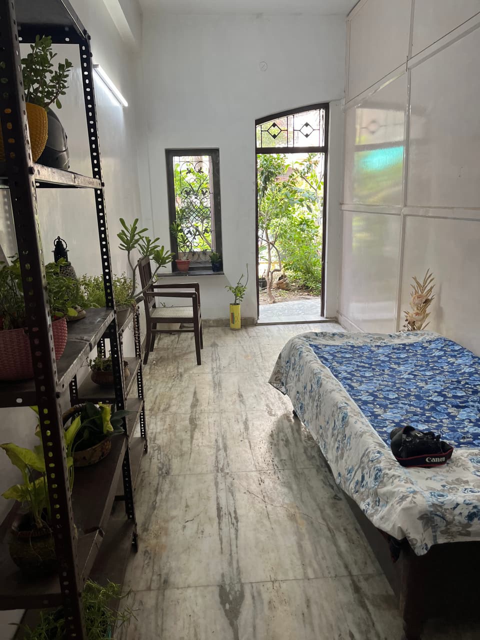 Bed and open floor space leading to the garden-side doorway.