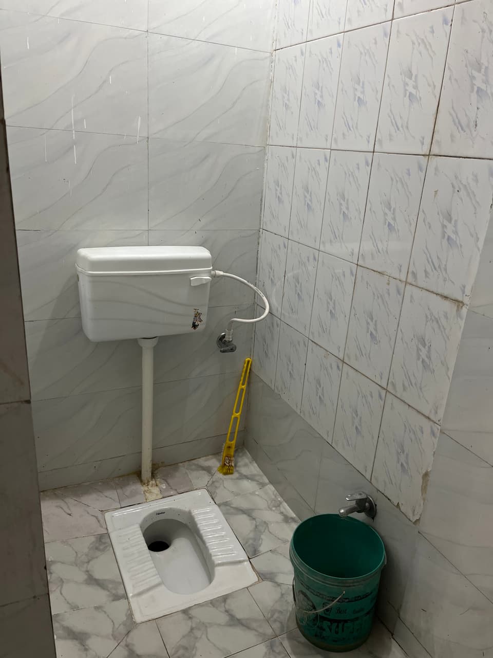 Toilet and tiled walls inside the attached washroom.