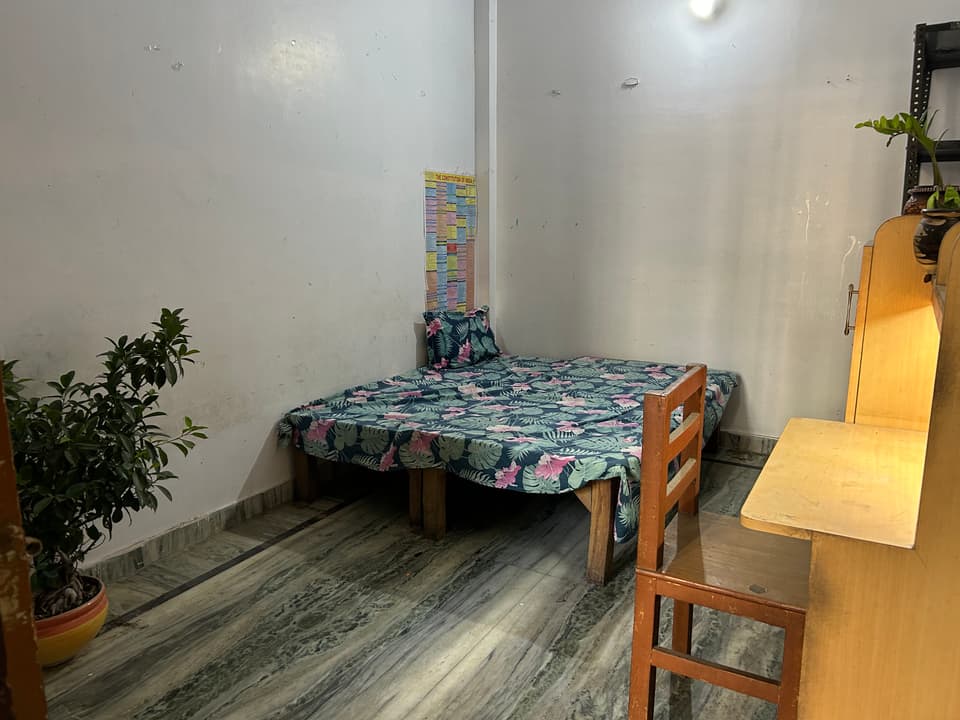 Bed, study desk, chair, and storage inside the spacious room.