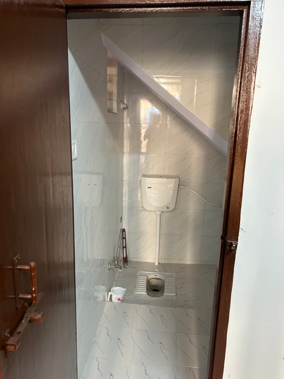 Toilet and tiled walls inside the attached washroom.