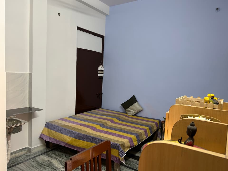 Bed, kitchen counter, and study furniture inside the studio.